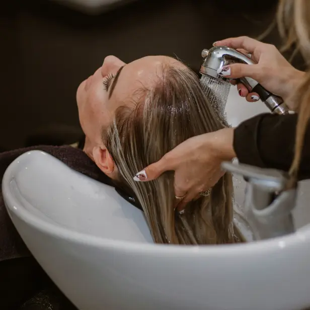 Frau erhält eine Haarwäsche im Friseursalon.